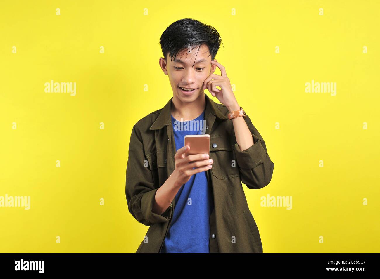 Porträt von smart Person junger asiatischer Mann tun Denken Gerture Sehen Sie sich das Smartphone-Display an Stockfoto