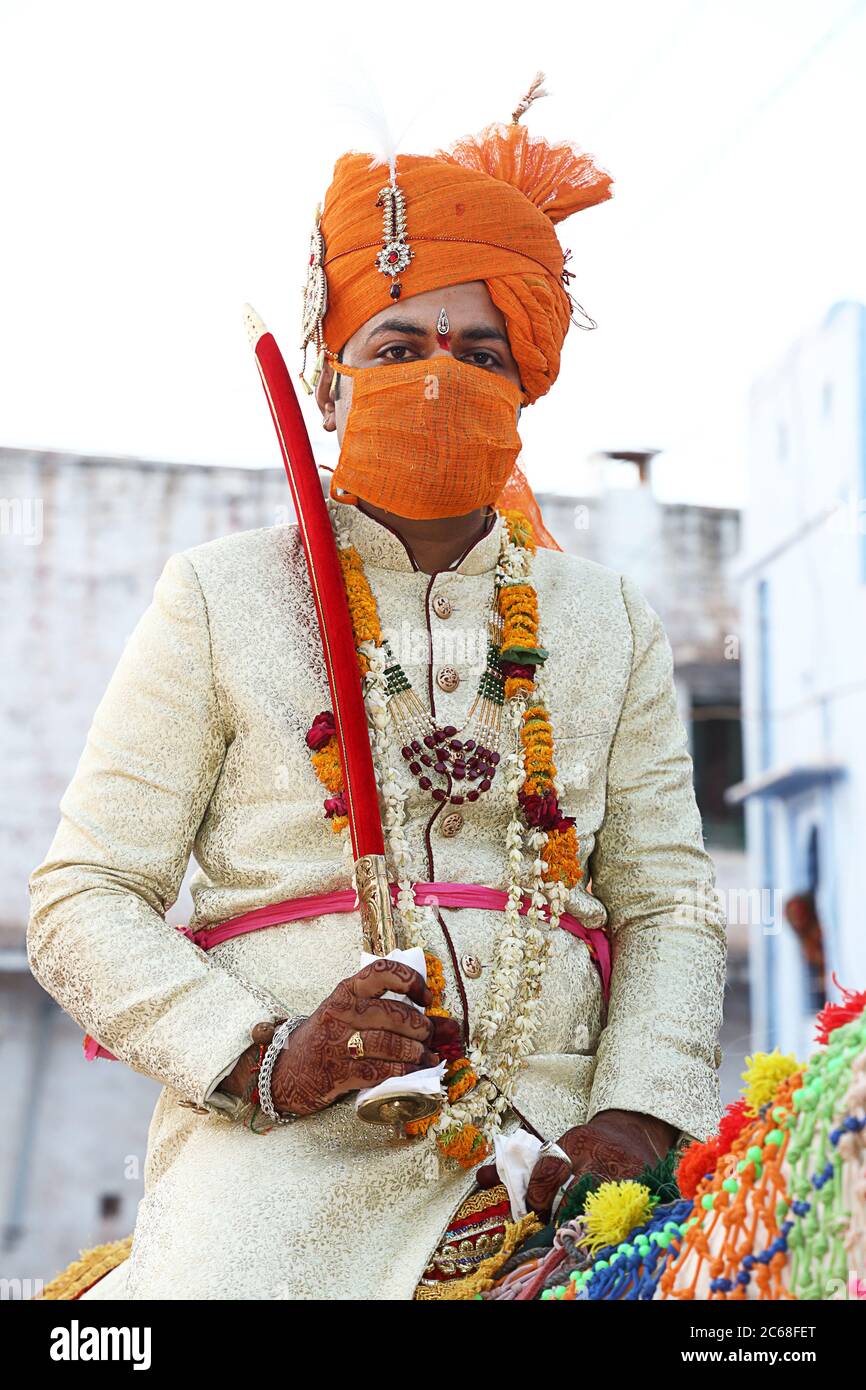 Jodhpur, Rajashtbn, Indien. 30. Juni 2020: Indischer Bräutigam trägt Maske auf Pferd sitzend, Menschen heiraten nach Leichtigkeit in Sperre während COVID-19 pa Stockfoto