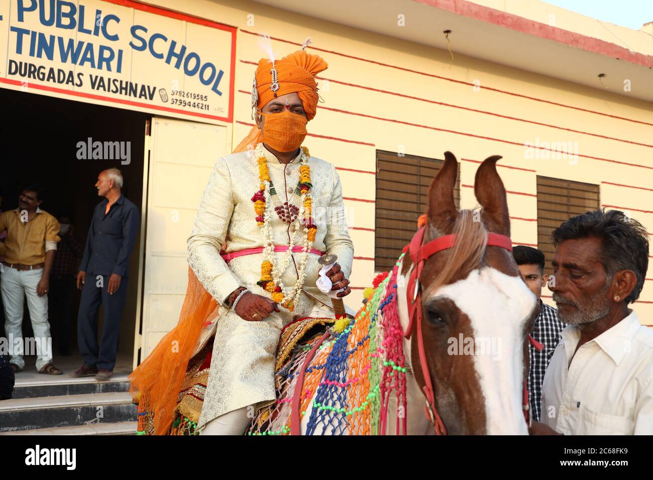 Jodhpur, Rajashtbn, Indien. 30. Juni 2020: Indischer Bräutigam trägt Maske auf Pferd sitzend, Menschen heiraten nach Leichtigkeit in Sperre während COVID-19 pa Stockfoto