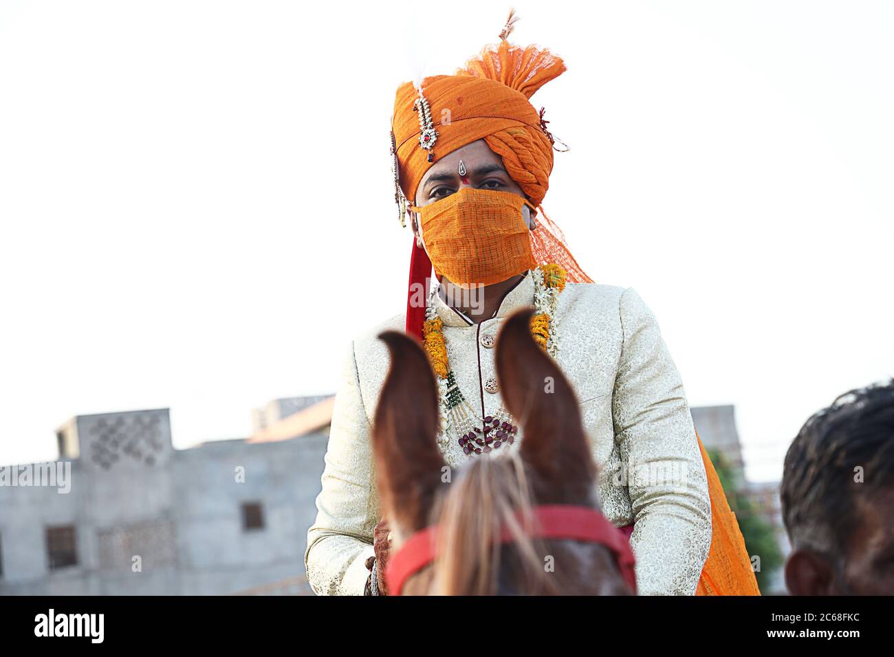 Jodhpur, Rajashtbn, Indien. 30. Juni 2020: Indischer Bräutigam trägt Maske auf Pferd sitzend, Menschen heiraten nach Leichtigkeit in Sperre während COVID-19 pa Stockfoto