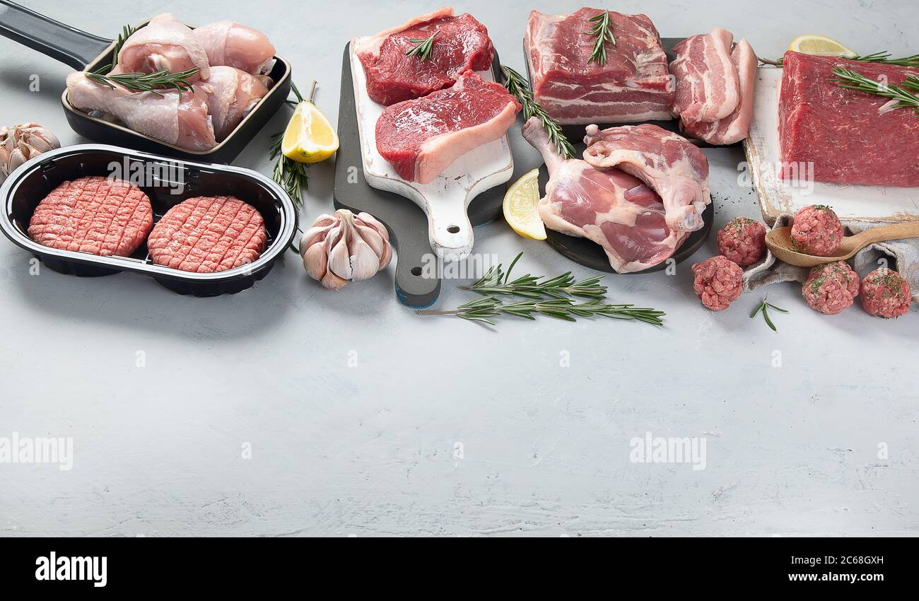 Auswahl an rohem Fleisch auf grauem Hintergrund. Bild mit Kopierbereich Stockfoto