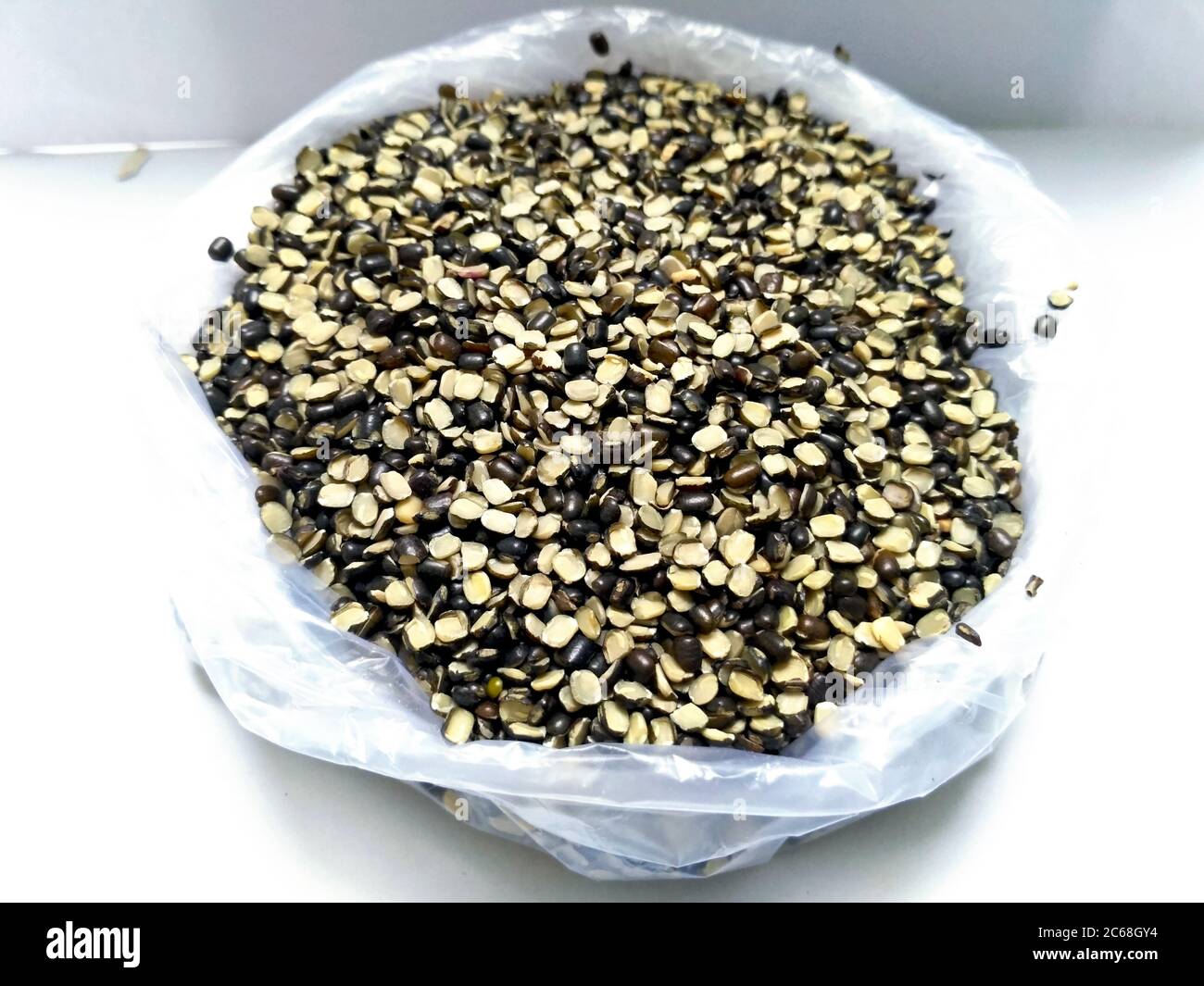 Split Black Lentil auch bekannt als Black Gram, Black Urad Dal, Vigna Mungo, Urad Bean, Urad Dal, Minapa Pappu, Mungo Bean oder Black Matpe Bean isoliert auf Stockfoto