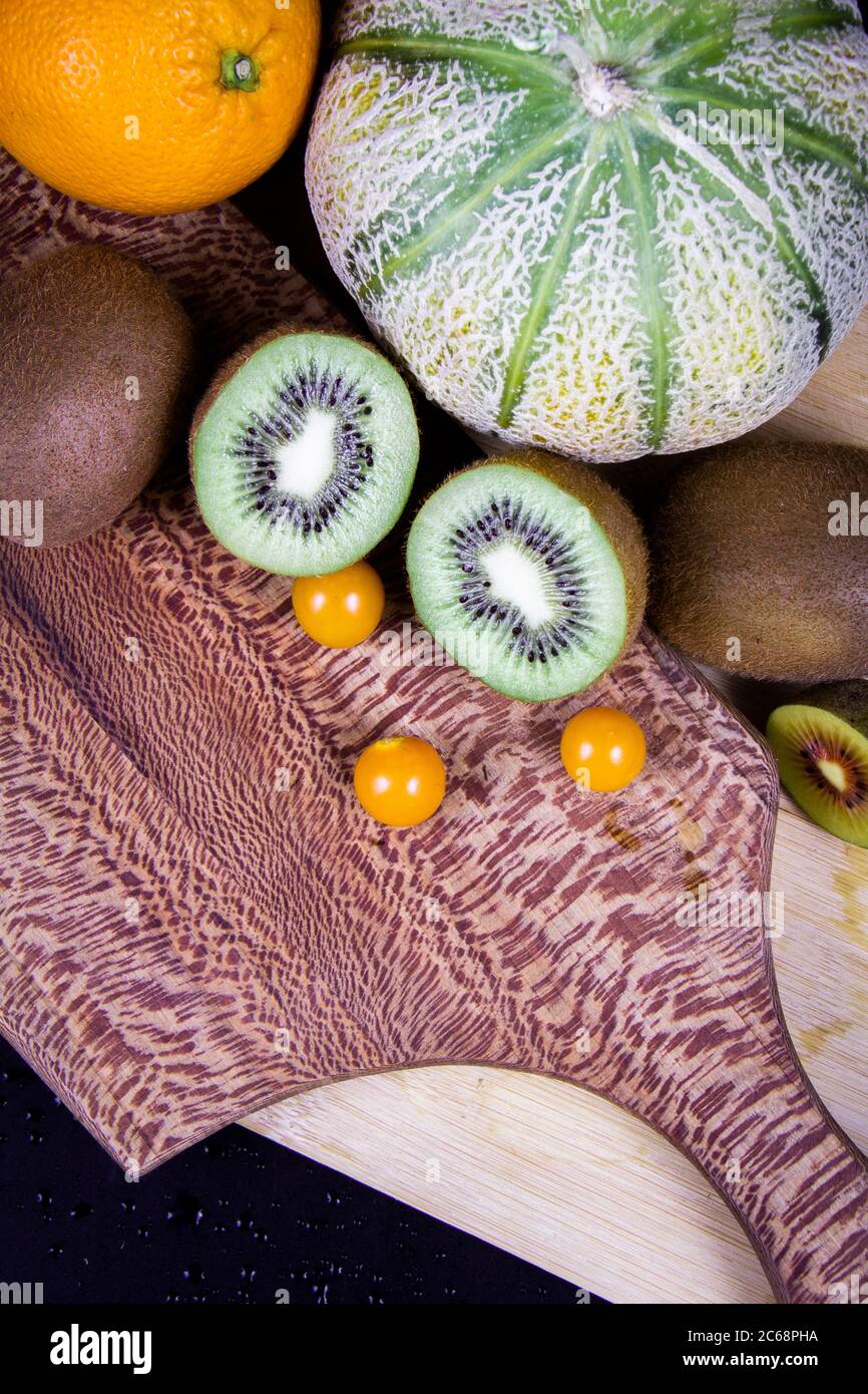 Eine Honigmelone, einige grüne Kiwifruits, eine frische Orange und einige chinesische Laternen. Stockfoto
