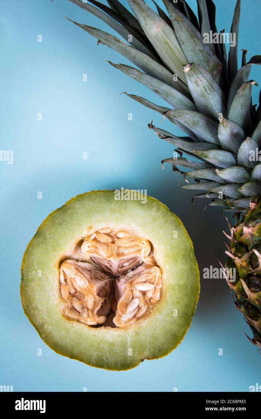 Eine frische Ananas in der Nähe von anderthalb grünen Honigmelone. Stockfoto