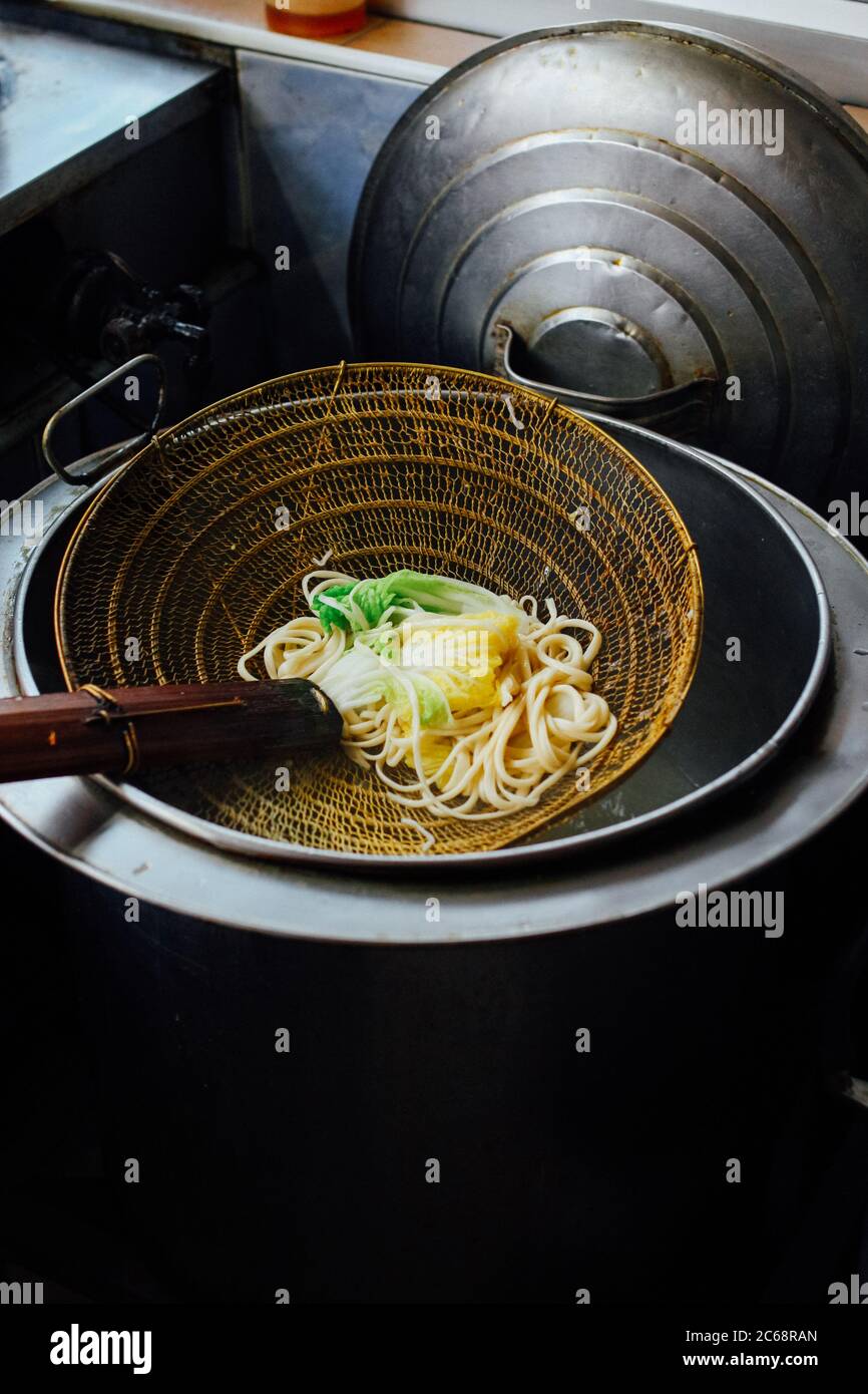 Gebrühtes gelbes Ei, das auf einem Sieb ruht Stockfoto