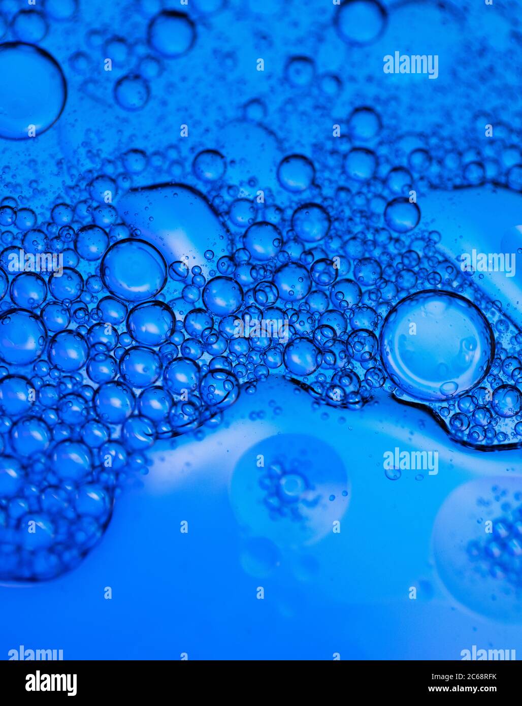 Öl bläht in Wasser. Blaue und schwarze Farben zusammen. Stockfoto