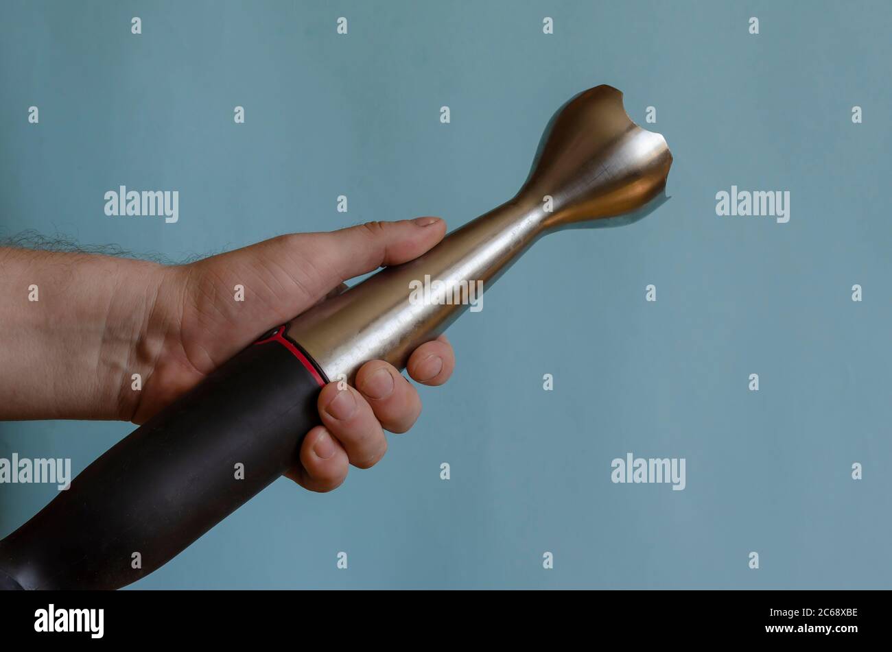 Hand hält eine Küchenarmatur mit einer Düse. Linke Hand eines Mannes mit  einem elektrischen Küchenhäcksler. Kaukasischer Mann 43-45 Jahre alt.  Küchengeräte Stockfotografie - Alamy