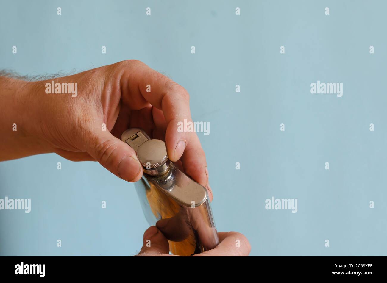 Handauflagebolken aus Kork. Herrenhände mit einer kleinen Flasche für Alkohol. Männliche europäische Rasse, 43-45 Jahre alt. Lifestyle Stockfoto