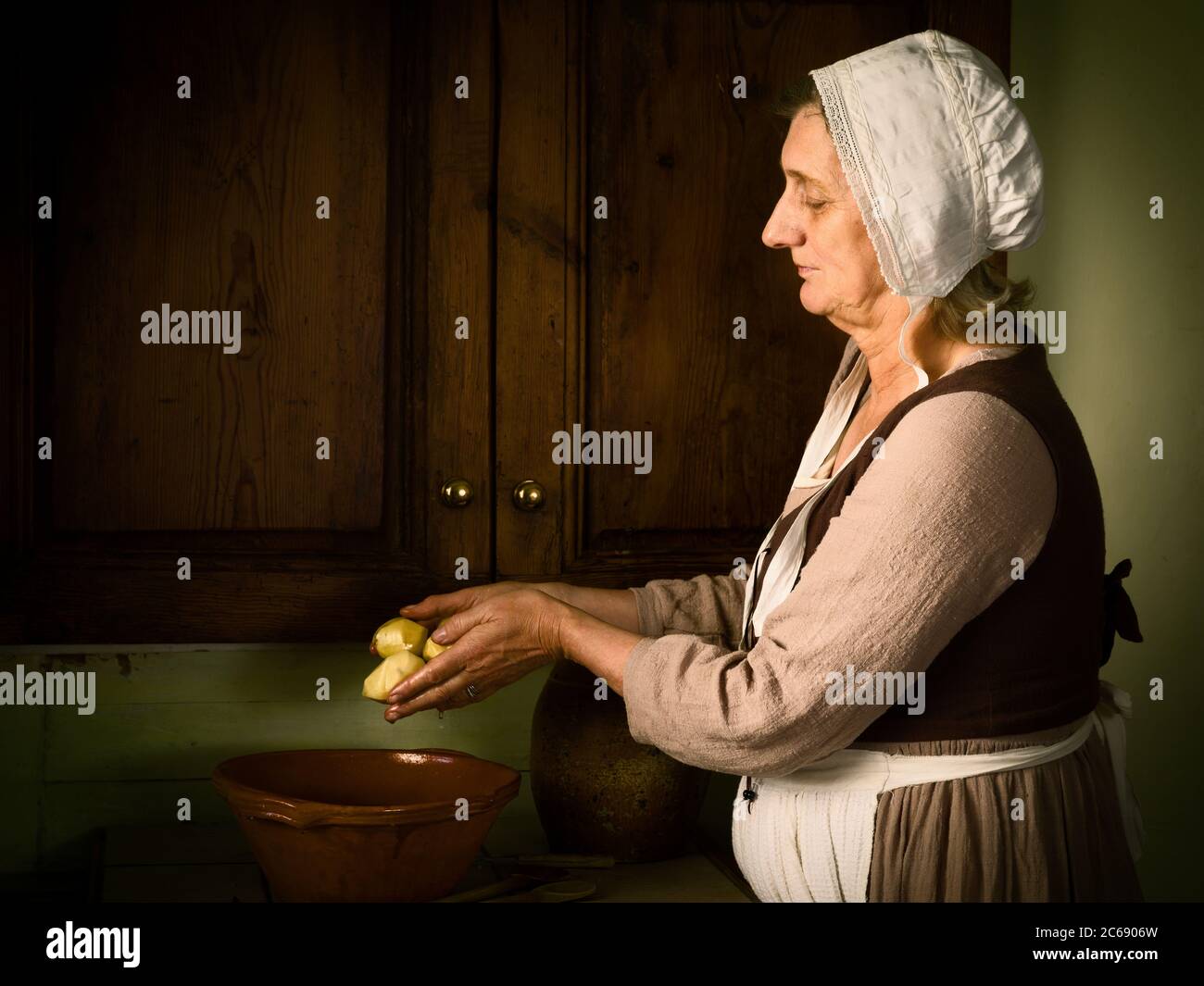 Alte Meister Stil Renaissance Porträt einer Frau, die Zubereitung von Speisen in eine antike Küche Stockfoto