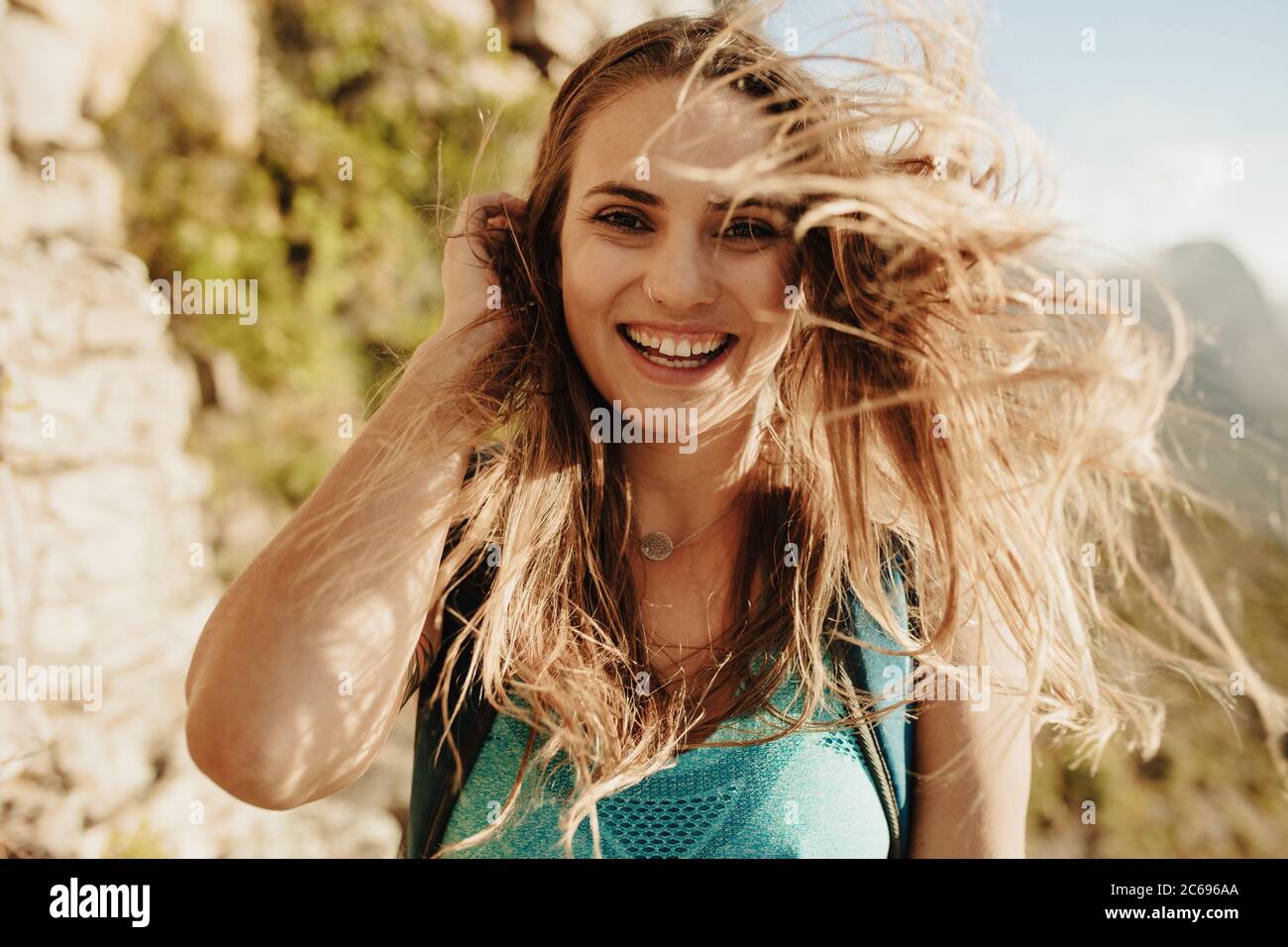 Nahaufnahme einer schönen Frau auf dem Bergpfad mit ihren Haaren. Weibliche Bergsteigerin mit Haaren im Wind. Stockfoto