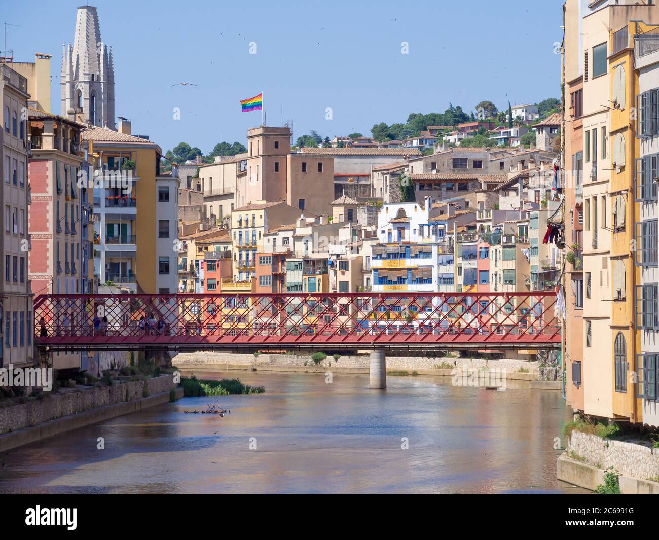 Girona City (Spanien) Blick auf die rote Eiffel Brücke über den Onyar Fluss. Die Regenbogenfahne über der Stadt Stockfoto