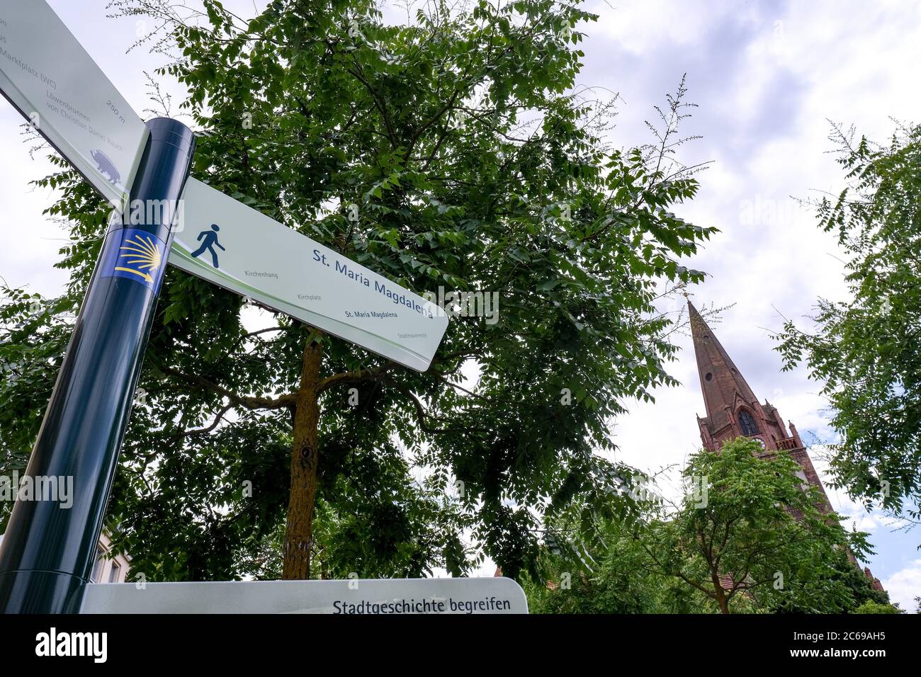 Eberswalde, Deutschland. Juli 2020. Ein Schild zeigt den Weg zur Kirche Maria Magdalena, die sich auf dem Jakobsweg befindet, gekennzeichnet durch eine stilisierte gelbe Schale. Die Kirche wird nach einem Brand im Dezember 2019 im Inneren renoviert. Mit Hilfe von Gerüsten wird der Ruß an den Wänden entfernt. Die Reparaturarbeiten sollten ein bis zwei Jahre dauern. Quelle: Jens Kalaene/dpa-Zentralbild/ZB/dpa/Alamy Live News Stockfoto