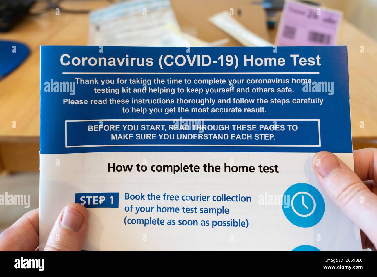 Coronavirus (Covid-19) Anweisungen, die einem Testkit für die Durchführung eines Heimtests beiliegen, der von den Händen eines Mannes gehalten und gelesen wird, Großbritannien Stockfoto