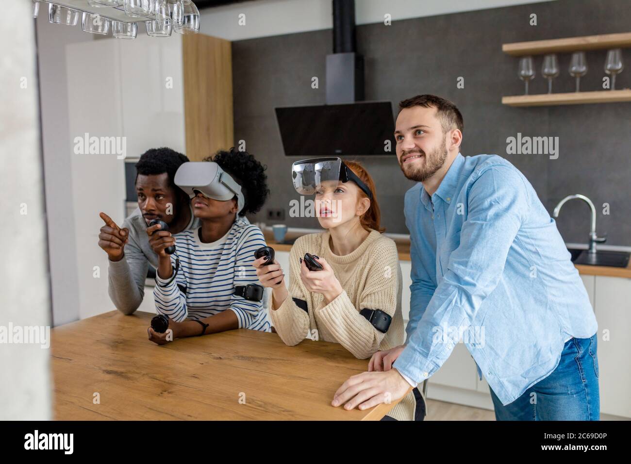 Virtuelle Schlacht von zwei Multirassischen Teams, bestehend aus liebevolle afrikanische und kaukasische Paare spielen in virtuellen Spielen Jungs unterstützen und unterrichten die Stockfoto