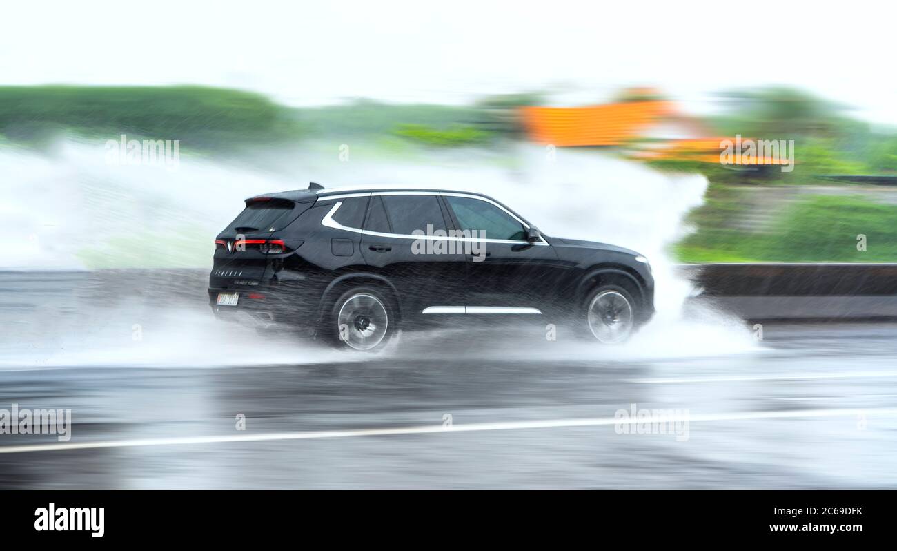 Silhouette der schnellen Autos auf dem Boulevard im Regen mit Spritzwasser zu erhöhen die dramatische und majestätische für den modernen Verkehr in Vung Tau Stockfoto