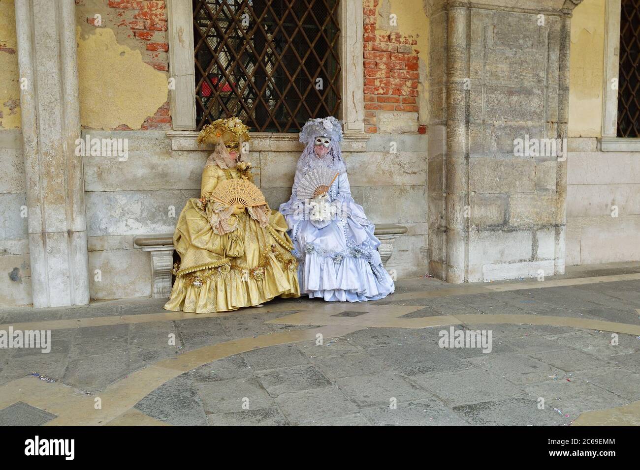 Venedig, Italien - 7. März 2011: Zwei nicht identifizierte Maskierte in Gold und Weiß auf dem Markusplatz während des Karnevals von Venedig. Die 2011 Stockfoto