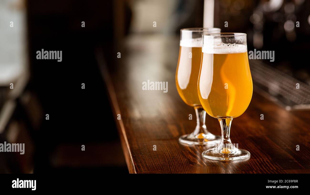 Service im Pub. Gläser mit Bier in Licht auf Holztheke Stockfoto