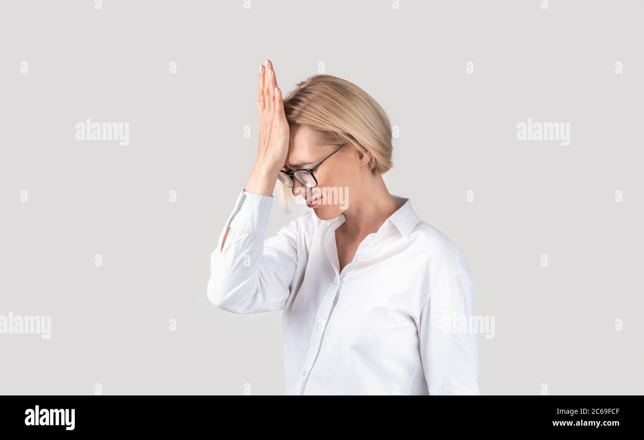 Verärgert Sekretärin erleben Deadline Stress oder leiden an Migräne auf hellem Hintergrund Stockfoto