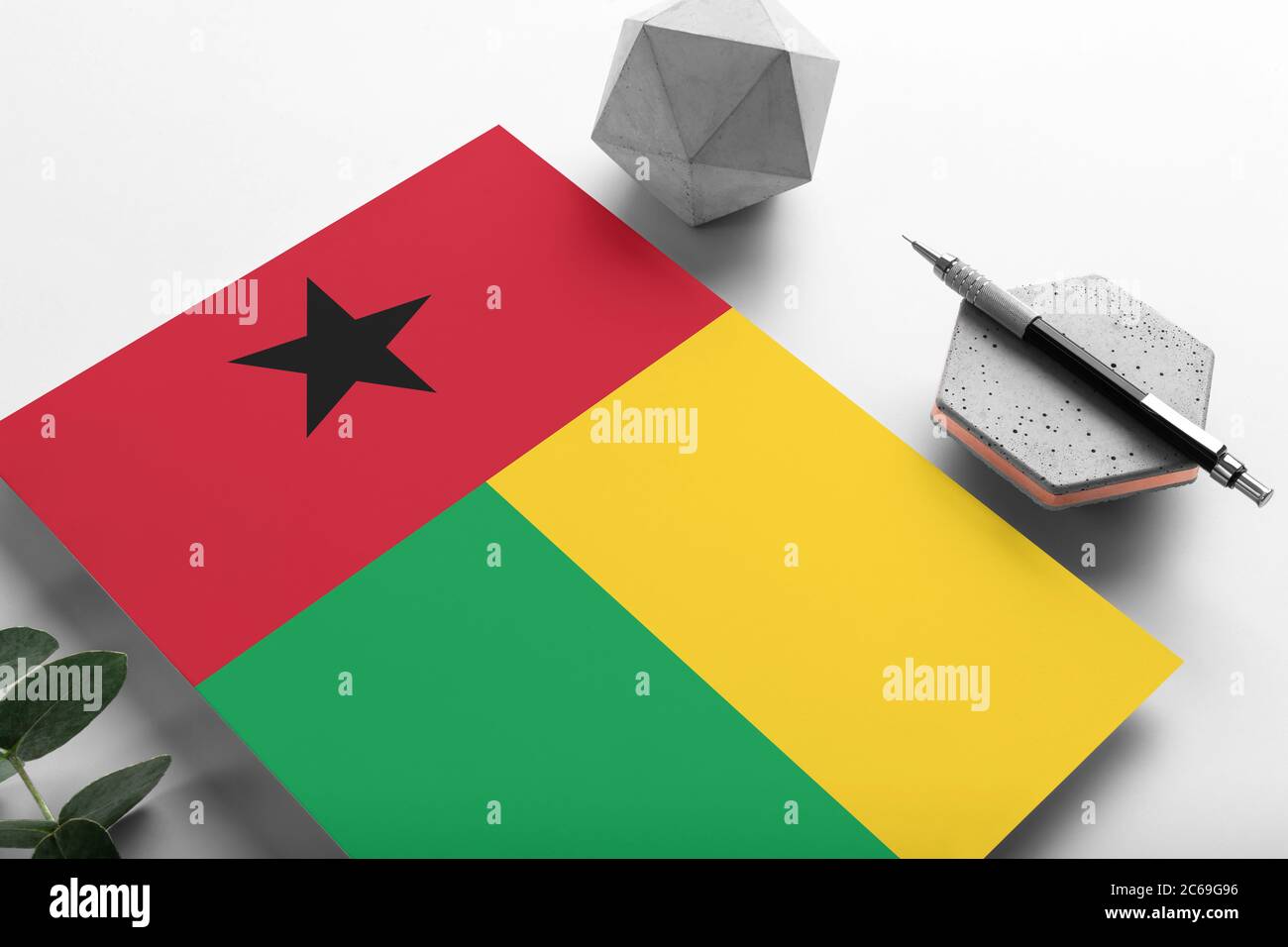 Guinea-Flagge auf minimalistischem Papier Hintergrund. Nationale Einladung Brief mit stilvollen Stift auf Stein. Kommunikationskonzept. Stockfoto