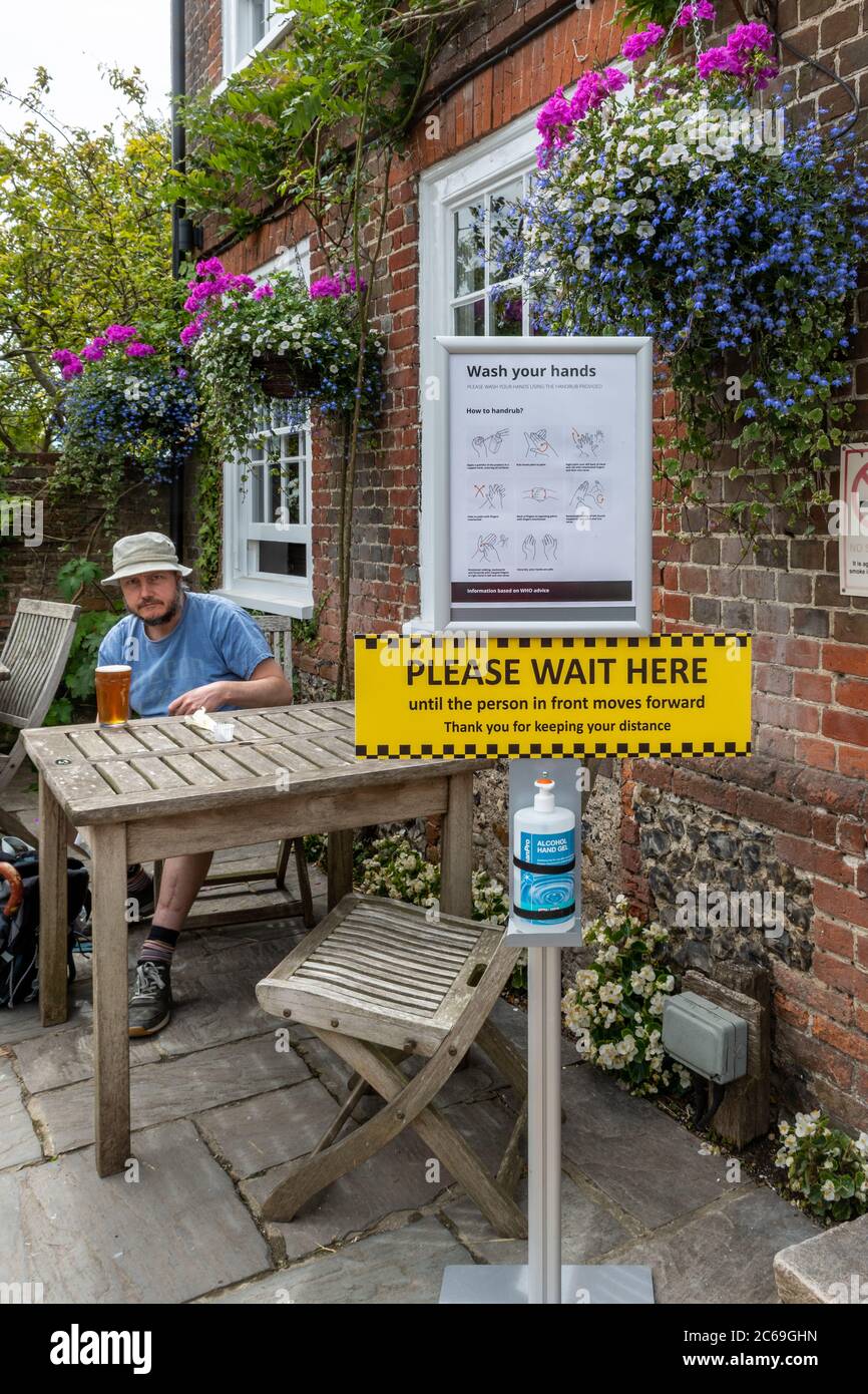 Pubs haben in England wieder geöffnet, nachdem die Beschränkungen für Coronavirus Covid-19 gelockert haben, 7. Juli 2020, Großbritannien. Pub mit Handwaschstation und Sicherheitsschildern draußen Stockfoto