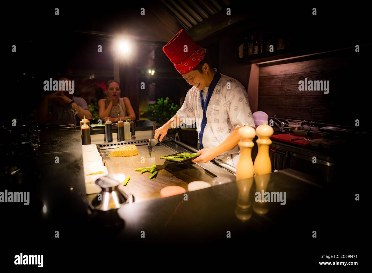 Mai, 2018 - Ari Atoll, Malediven: Fröhlicher Teppanyaki-Koch kocht Gemüse-Teppan im japanischen Steakhouse auf Mishi Sushi. Gourmet-Essen, Luxus-Restaurant Stockfoto