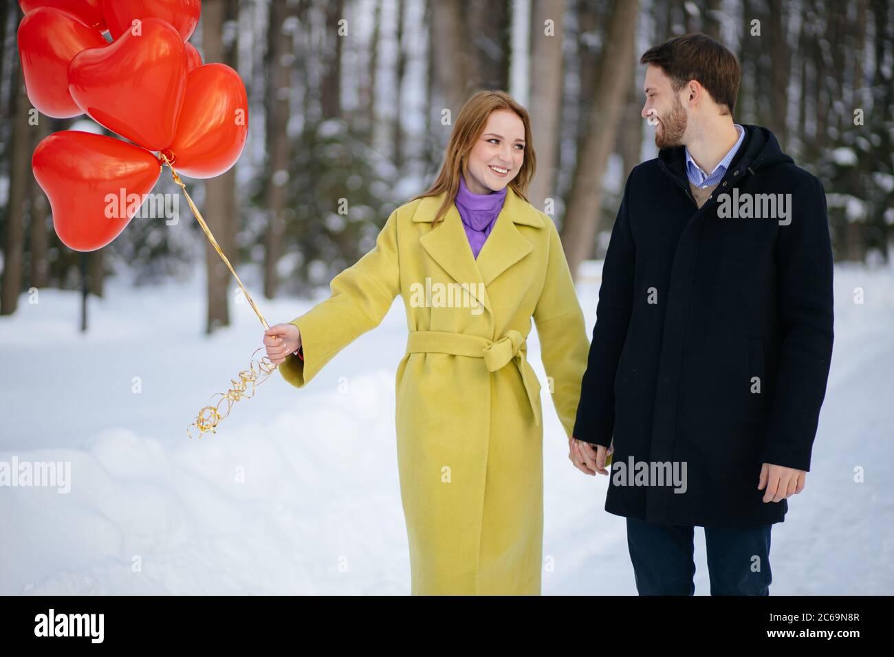 Fröhlich glücklich kaukasischen Paar, schöne Frau und gutaussehende Kerl auf einem romantischen Datum mit roten Luftballons. Liebe, romantische Datum Konzept Stockfoto