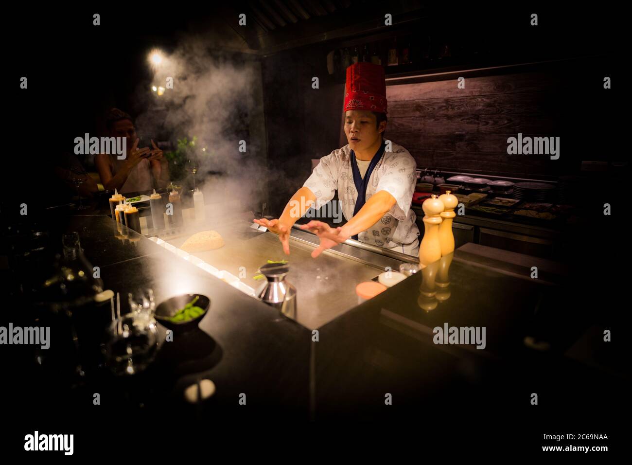 Mai, 2018 - Ari Atoll, Malediven: Fröhlicher Teppanyaki-Koch kocht Gemüse-Teppan im japanischen Steakhouse auf Mishi Sushi. Gourmet-Essen, Luxus-Restaurant Stockfoto
