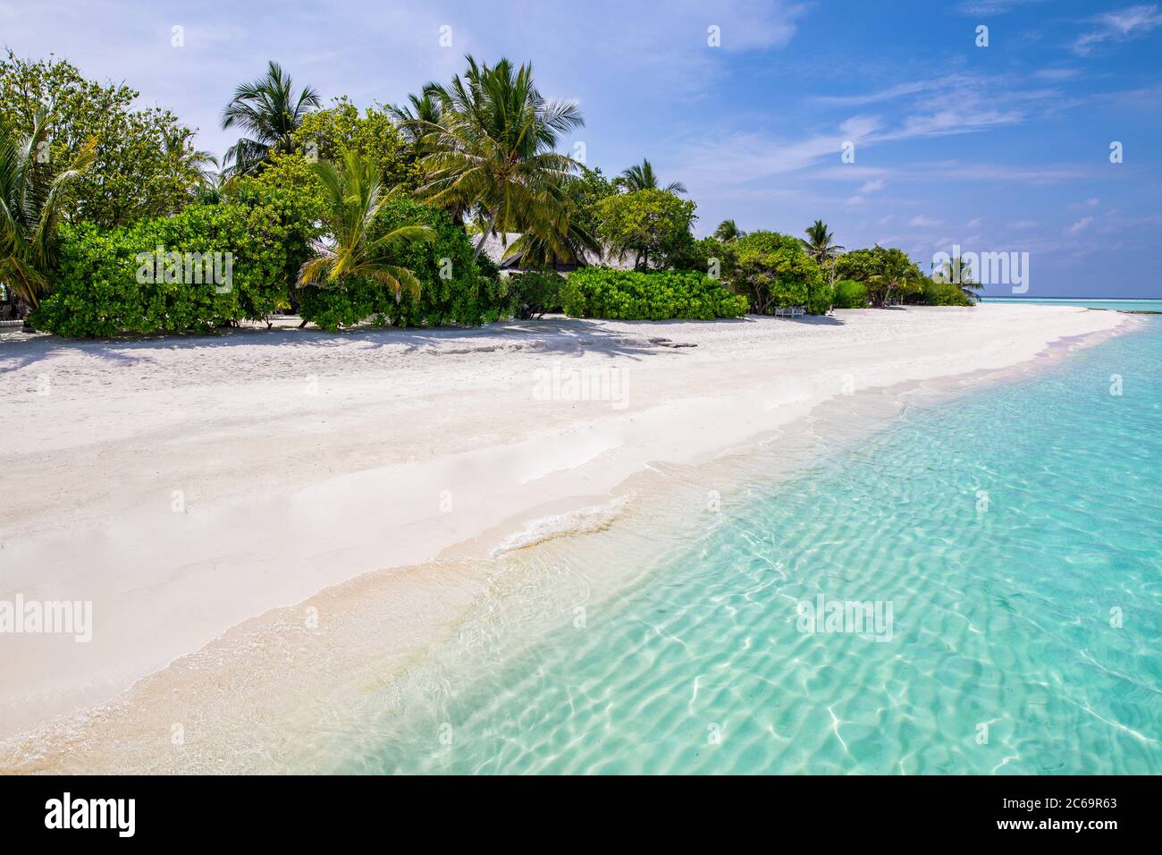 Schöner Strand mit Palmen launischen Himmel. Sommerurlaub Reise Urlaub Hintergrund Konzept. Malediven Paradies Strand. Luxusreisen Sommerurlaub Stockfoto