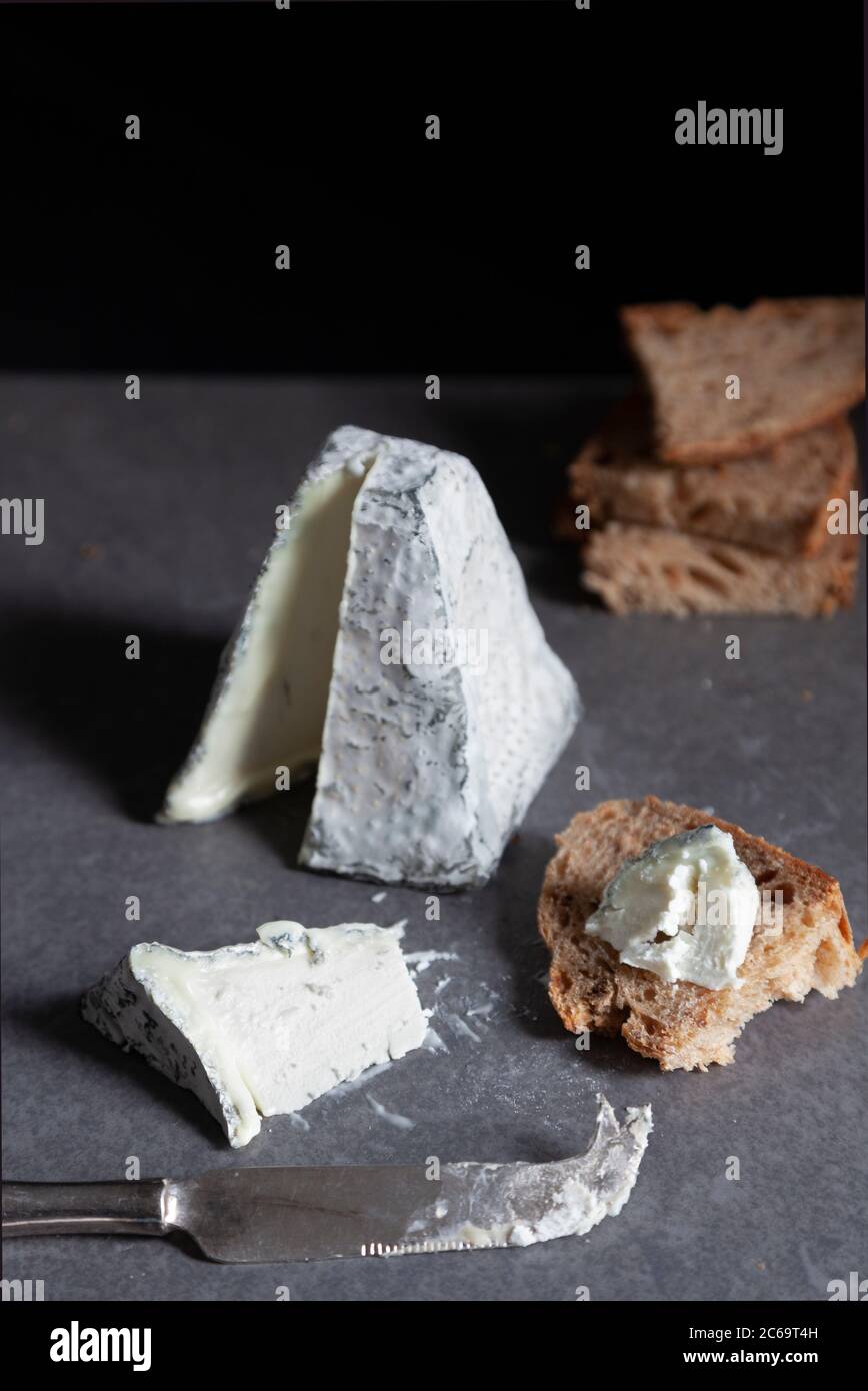 Eine mit Asche überzogene Ziegenkäse-Pyramide mit Sauerteig-Brot Stockfoto