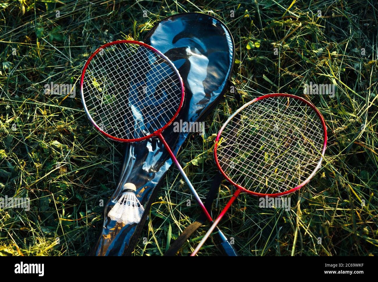 Zwei gekreuzte Badmintonschläger auf einem Gras. Sport und Sommer Outdoor-Aktivitäten Stockfoto