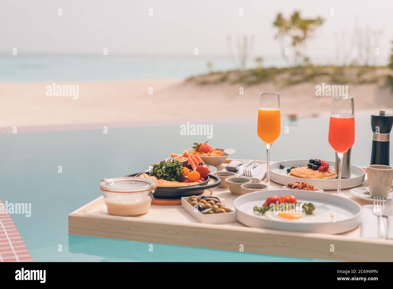 Frühstück im Swimmingpool, schwimmendes Frühstück im tropischen Resort. Tisch relaxen im ruhigen Poolwasser, gesundes Frühstück und Obstteller am Resortpool Stockfoto