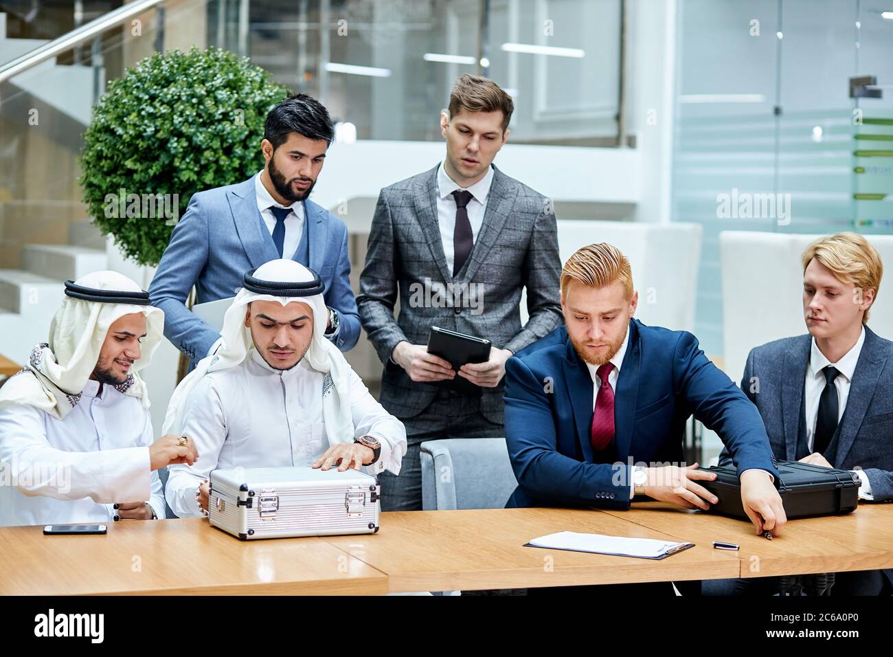 Scheichs zeigen Geld, falls sie neue Technologie von kaukasiern kaufen. Geschäftskonzept Stockfoto