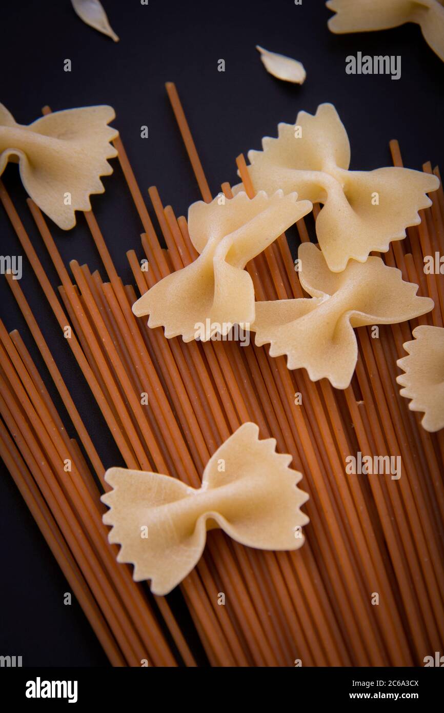 Pasta in Form und Pasta in Form. Pasta in verschiedenen Formen und Farben mit einer Vielzahl von Früchten und Holzgerichten. Stockfoto