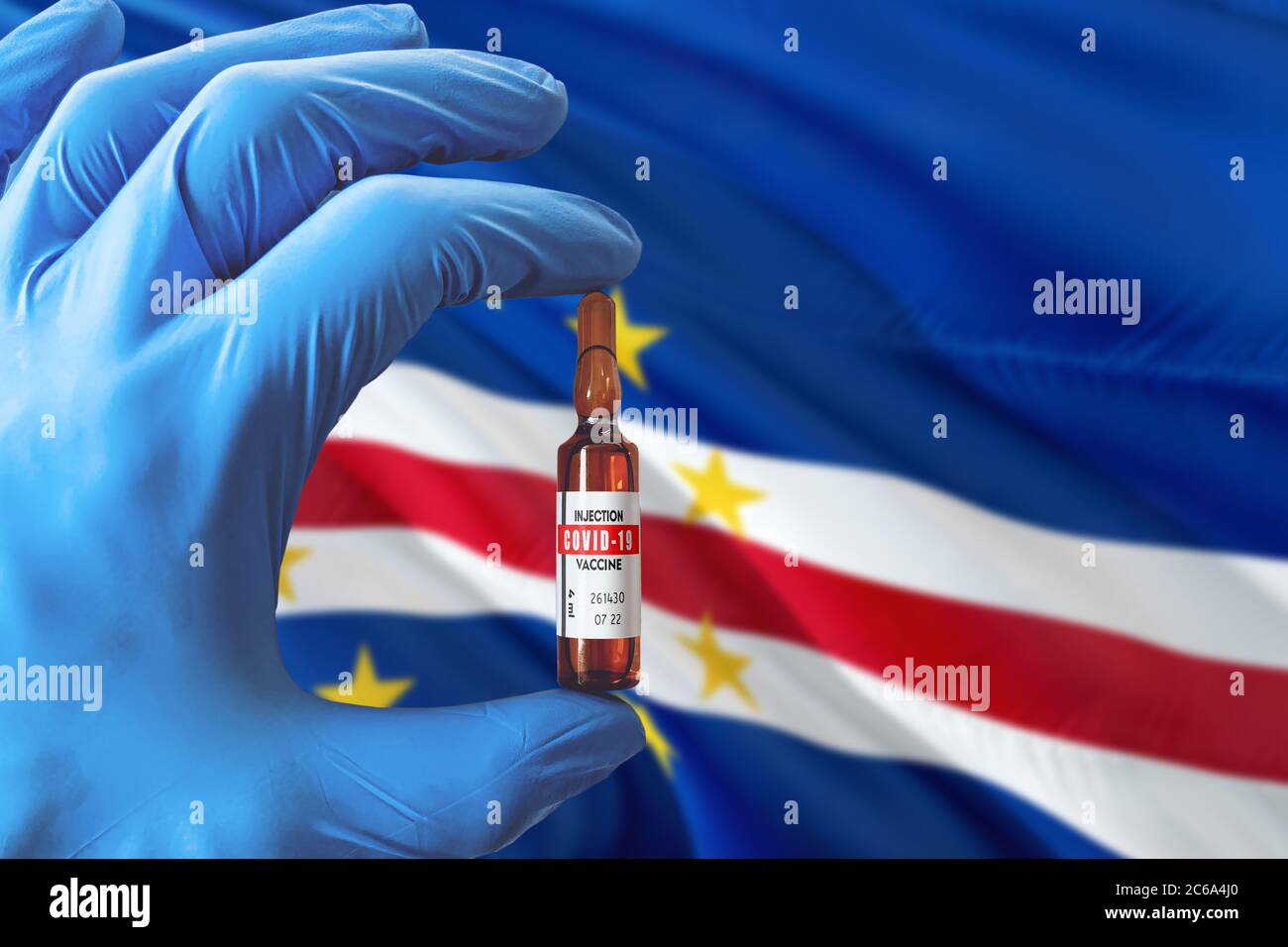 Kap Verde Flagge mit Coronavirus Covid-19 Konzept. Arzt mit blauen Schutzhandschuhen mit einer Impfstoffflasche. Epidemic Virus, Cov-19, Corona Stockfoto