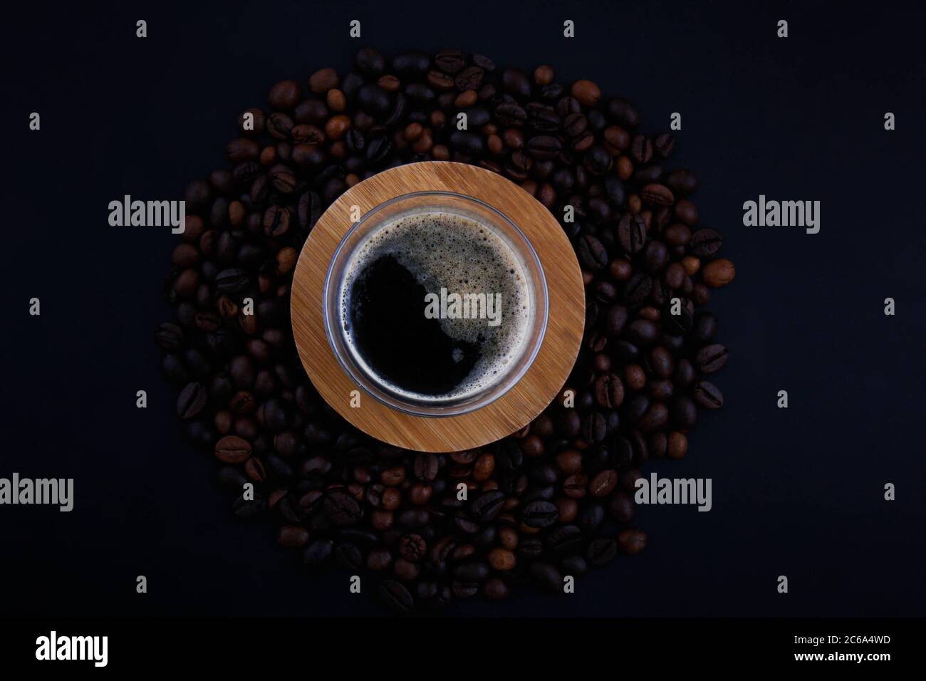 Verschiedene Kaffeesorten und genügend Sorten auf dem schwarzen Hintergrund in der Draufsicht, die auf das Holzbrett gegossen wird. Stockfoto