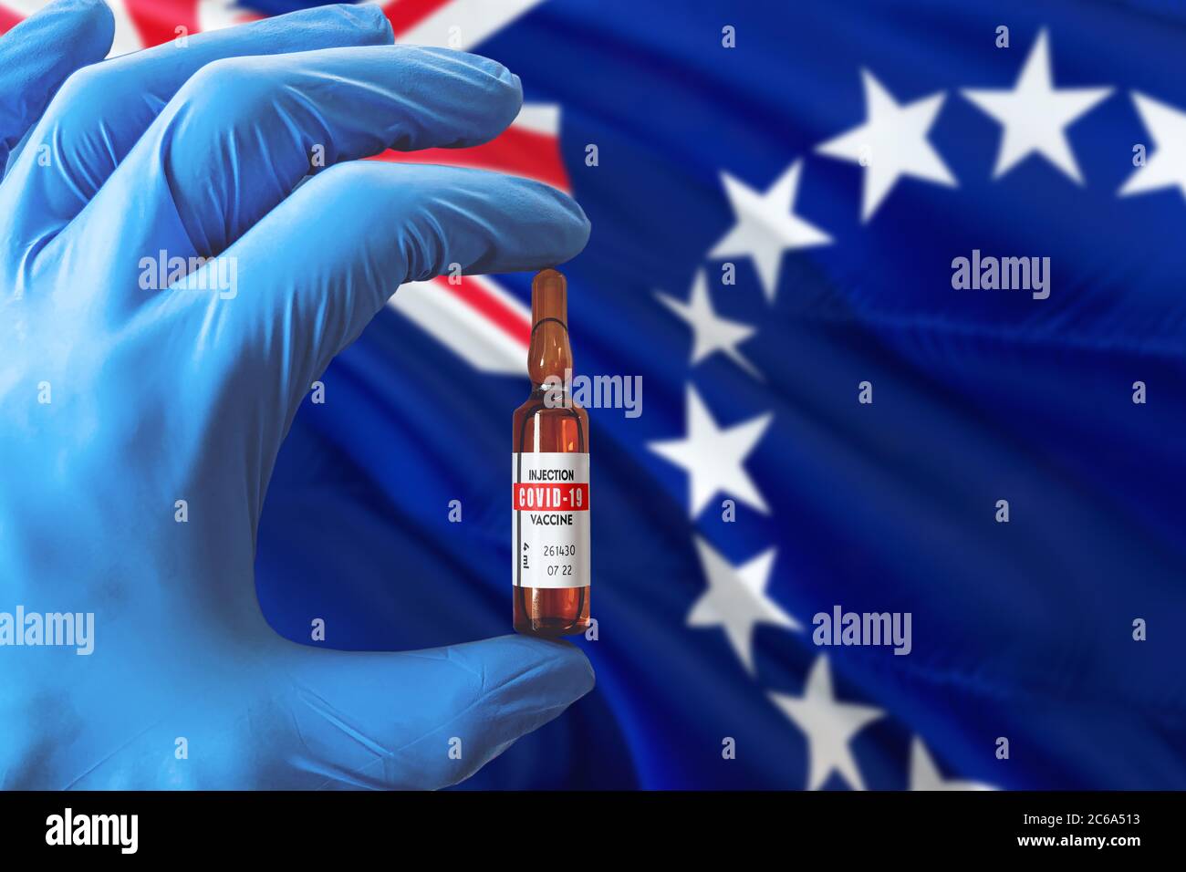 Flagge der Cookinseln mit Coronavirus Covid-19 Konzept. Arzt mit blauen Schutzhandschuhen mit einer Impfstoffflasche. Epidemic Virus, Cov-19, Coro Stockfoto