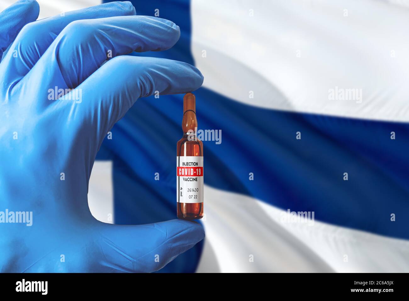 Finnland Flagge mit Coronavirus Covid-19 Konzept. Arzt mit blauen Schutzhandschuhen mit einer Impfstoffflasche. Epidemic Virus, Cov-19, Corona vi Stockfoto