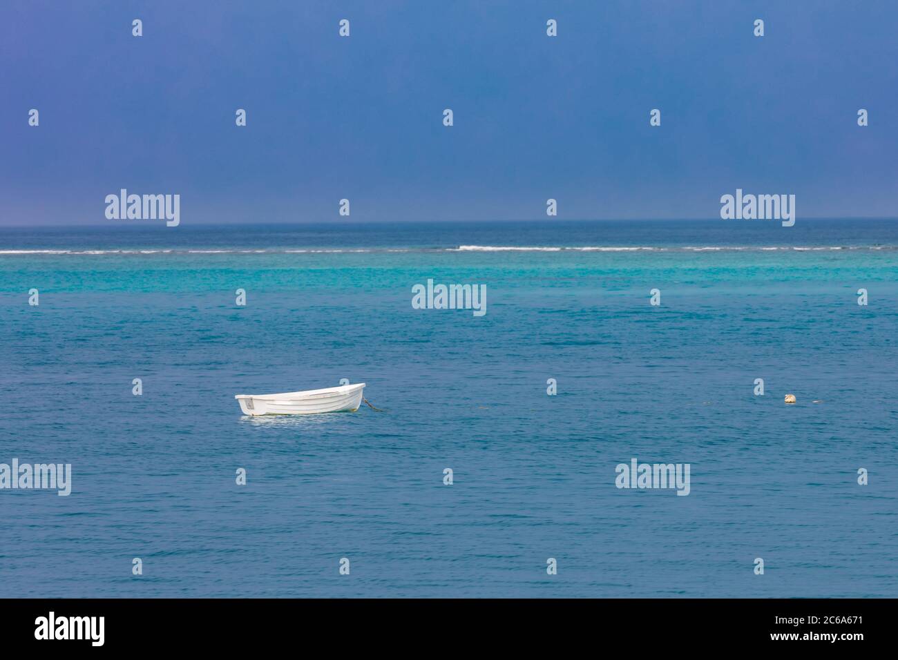 Kleines Fischerboot schwimmt auf blauem Meer. Einsames Holzboot, Ruhe und Schiffachtkonzept Stockfoto