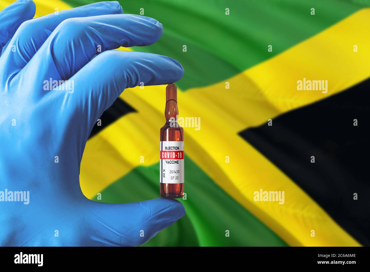 Jamaika Flagge mit Coronavirus Covid-19 Konzept. Arzt mit blauen Schutzhandschuhen mit einer Impfstoffflasche. Epidemic Virus, Cov-19, Corona vi Stockfoto