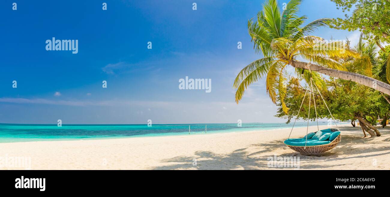 Tropisches Strandpanorama als Sommerlandschaft mit Strandschaukel oder Hängematte und weißem Sand und ruhigem Meer für Strandbanner. Perfekter Strandurlaub Stockfoto