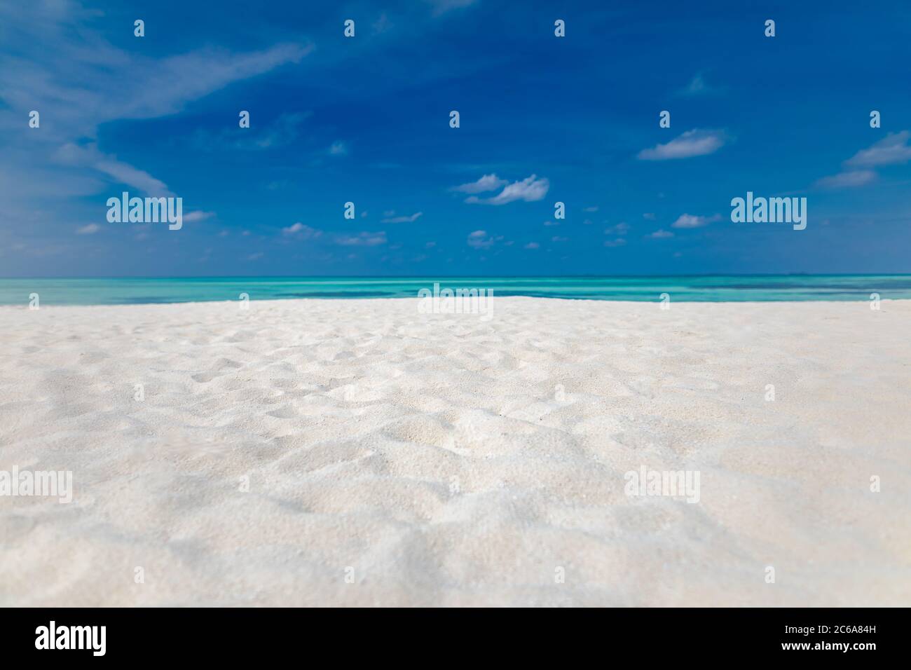 Minimale Aussicht auf den Strand, Meer Sand Himmel als entspannende Sommerlandschaft. Friedlicher tropischer Blick auf die Strandlandschaft. Wolken am blauen Himmel, ruhiges Strandkonzept Stockfoto