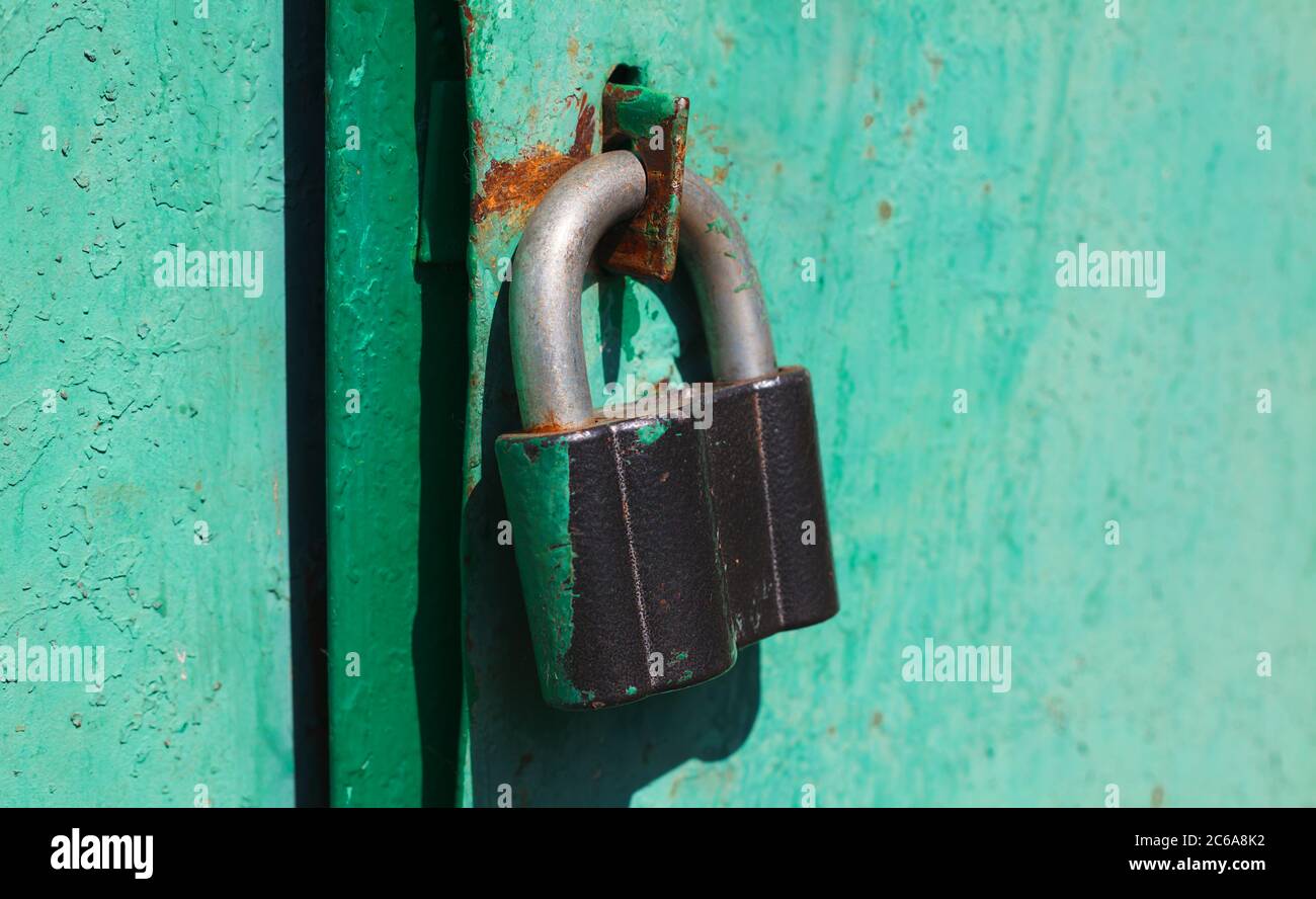An einer grünen Tür hing ein Eisenschloss Stockfoto