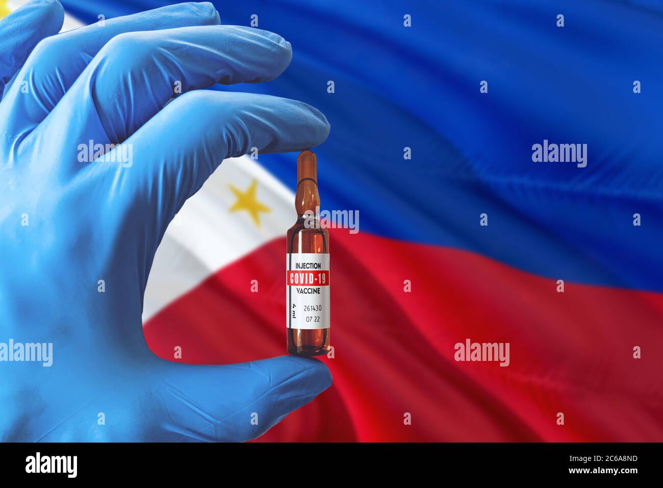 Philippinen Flagge mit Coronavirus Covid-19 Konzept. Arzt mit blauen Schutzhandschuhen mit einer Impfstoffflasche. Epidemic Virus, Cov-19, Coron Stockfoto