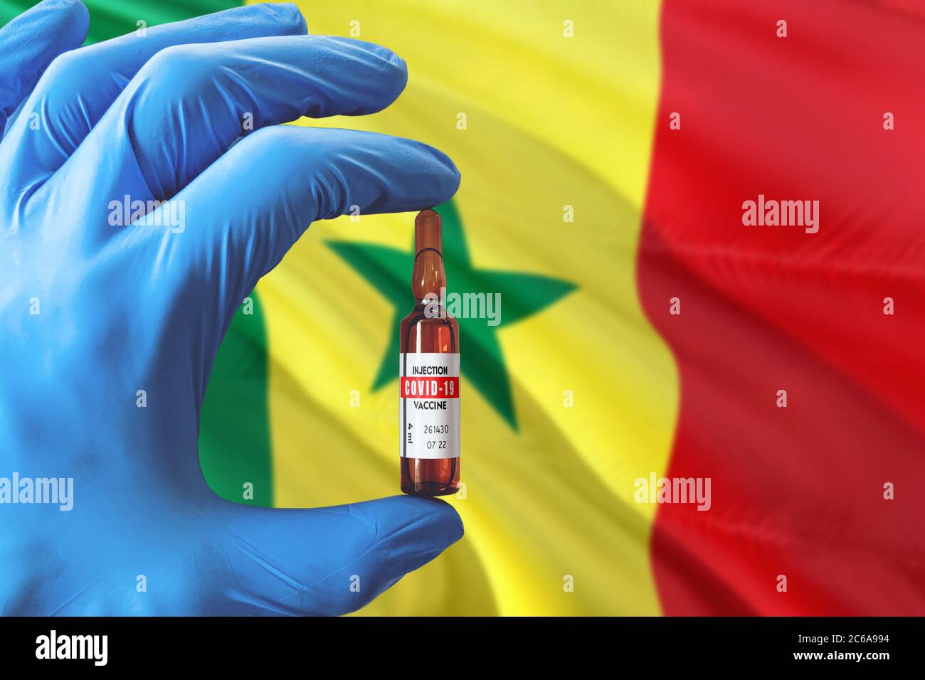 Senegal Flagge mit Coronavirus Covid-19 Konzept. Arzt mit blauen Schutzhandschuhen mit einer Impfstoffflasche. Epidemic Virus, Cov-19, Corona vi Stockfoto