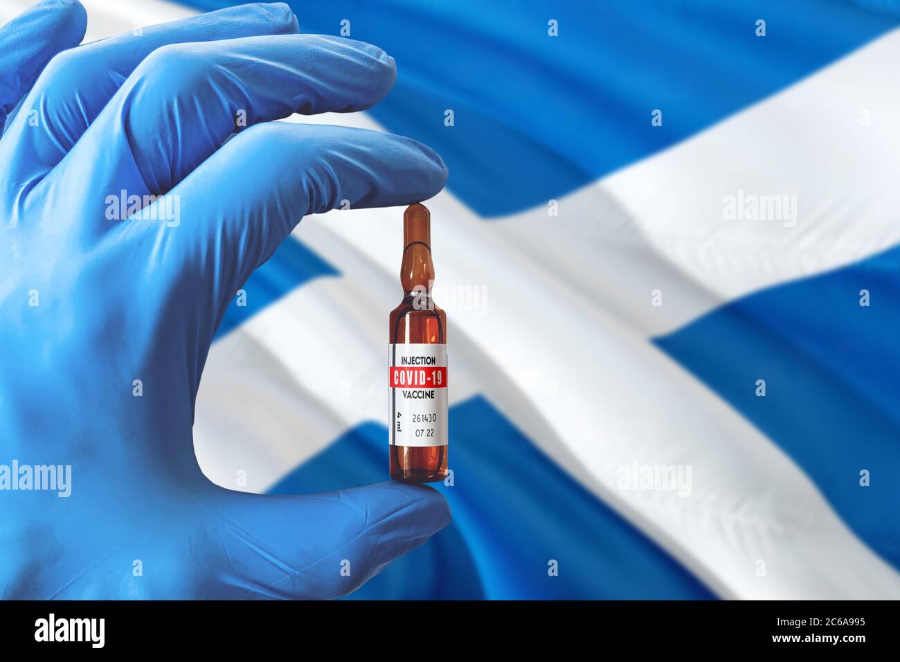 Schottland Flagge mit Coronavirus Covid-19 Konzept. Arzt mit blauen Schutzhandschuhen mit einer Impfstoffflasche. Epidemic Virus, Cov-19, Corona V Stockfoto