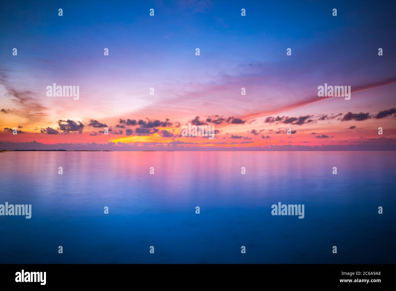 Ruhiges Meer mit Sonnenuntergang Himmel und Sonne durch die Wolken über. Meditation Ozean und Himmel Hintergrund. Ruhige Meereslandschaft. Horizont über dem Wasser. Stockfoto