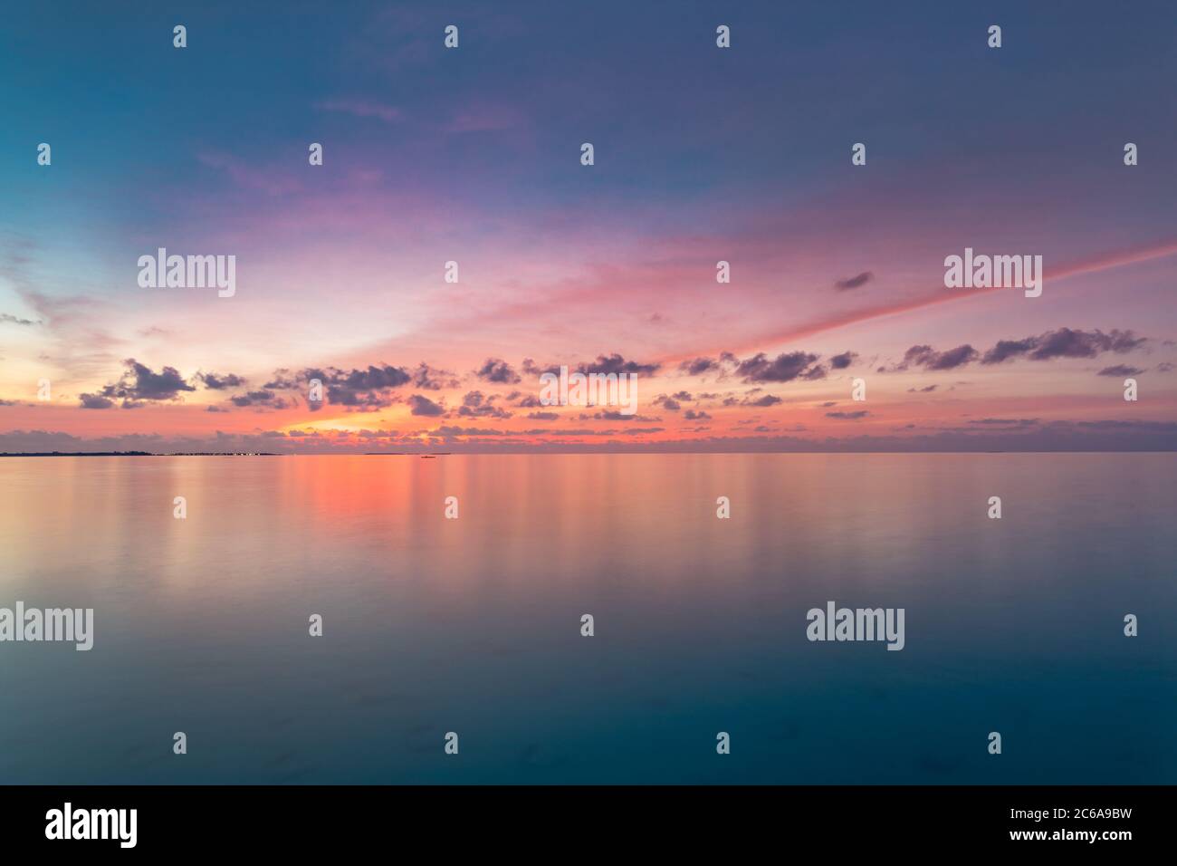 Ruhiges Meer mit Sonnenuntergang Himmel und Sonne durch die Wolken über. Meditation Ozean und Himmel Hintergrund. Ruhige Meereslandschaft. Horizont über dem Wasser. Stockfoto