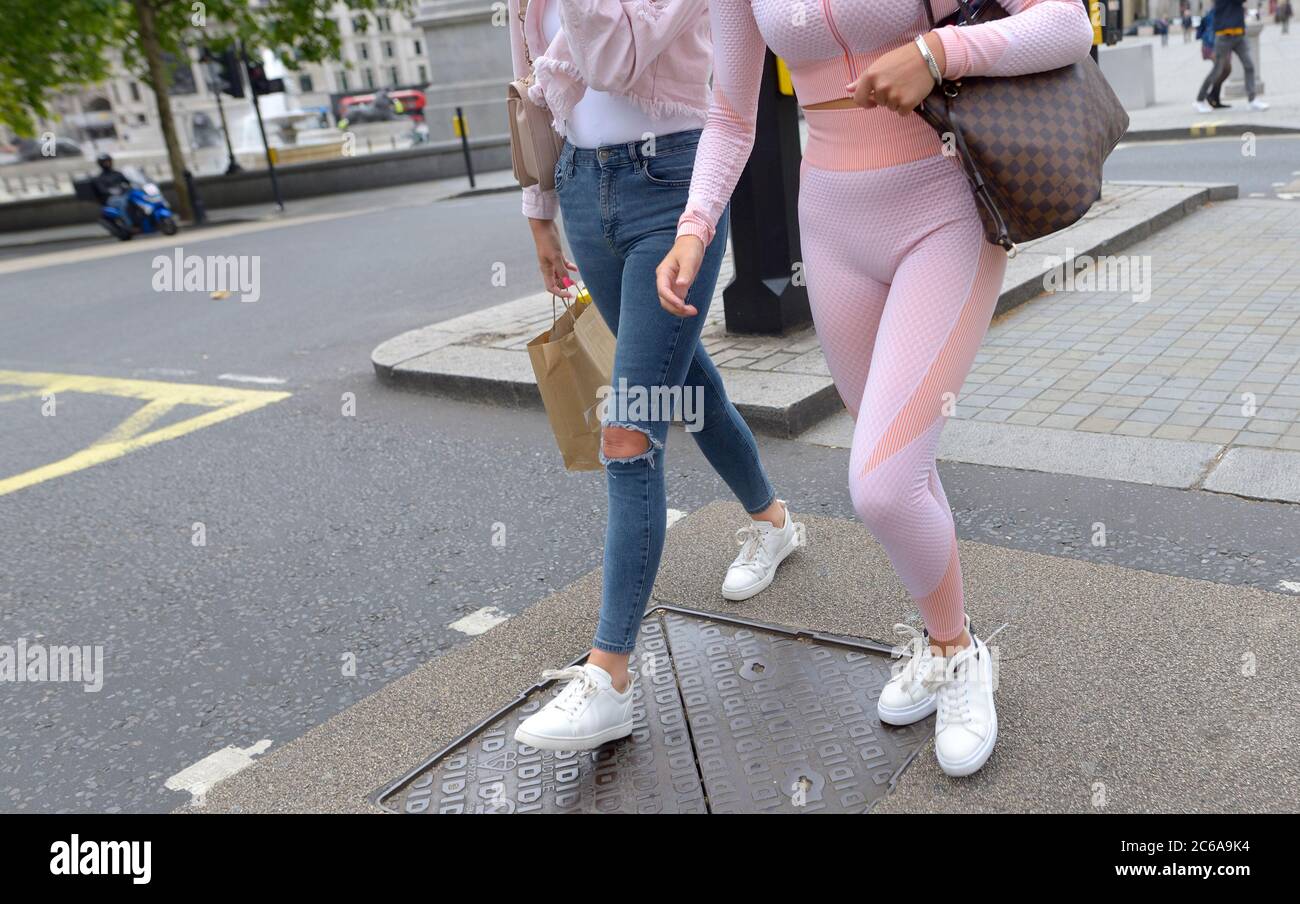 London, England, Großbritannien. Zwei junge Frauen in Westminster tragen zerrissene Jeans und Leggings Stockfoto