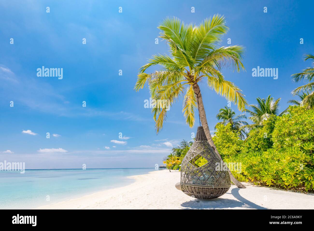 Tropischer Strand Hintergrund als Sommerlandschaft mit Strandschaukel oder Hängematte und weißem Sand und ruhiges Meer für Strand Banner. Perfekter Urlaub am Strand Stockfoto