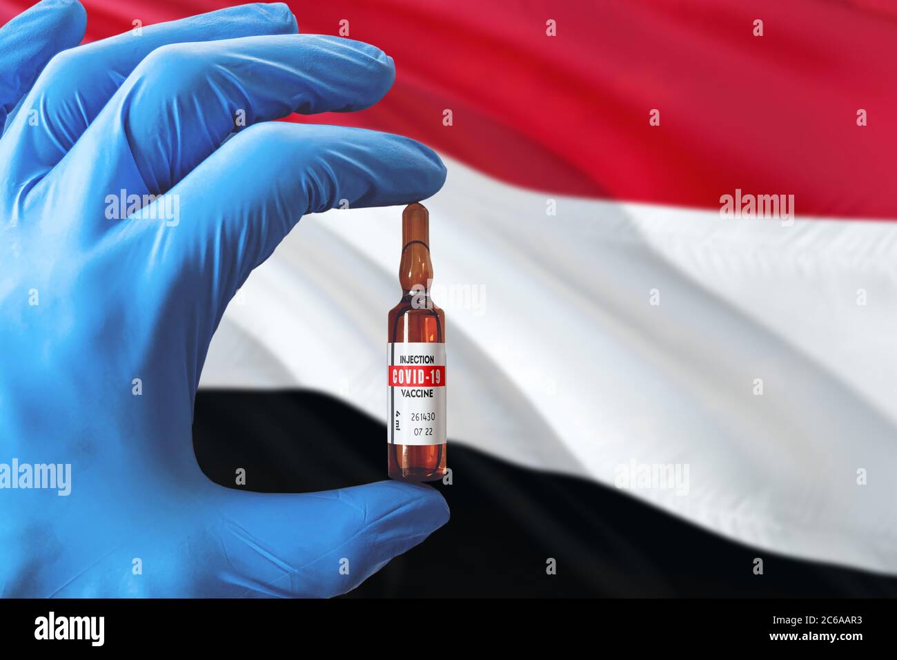Jemen Flagge mit Coronavirus Covid-19 Konzept. Arzt mit blauen Schutzhandschuhen mit einer Impfstoffflasche. Epidemic Virus, Cov-19, Corona viru Stockfoto